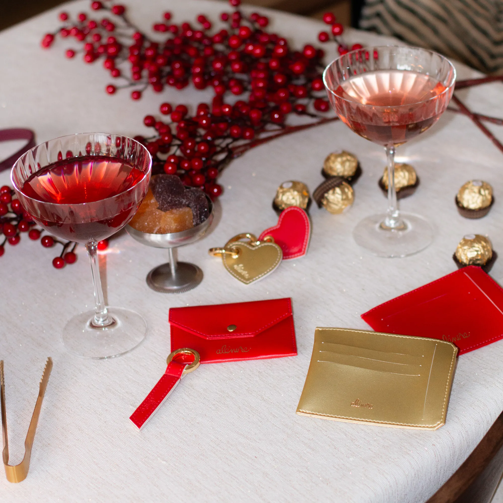 Porte-cartes et accessoires Alénore rouges et dorés sur une table décorée pour Noël